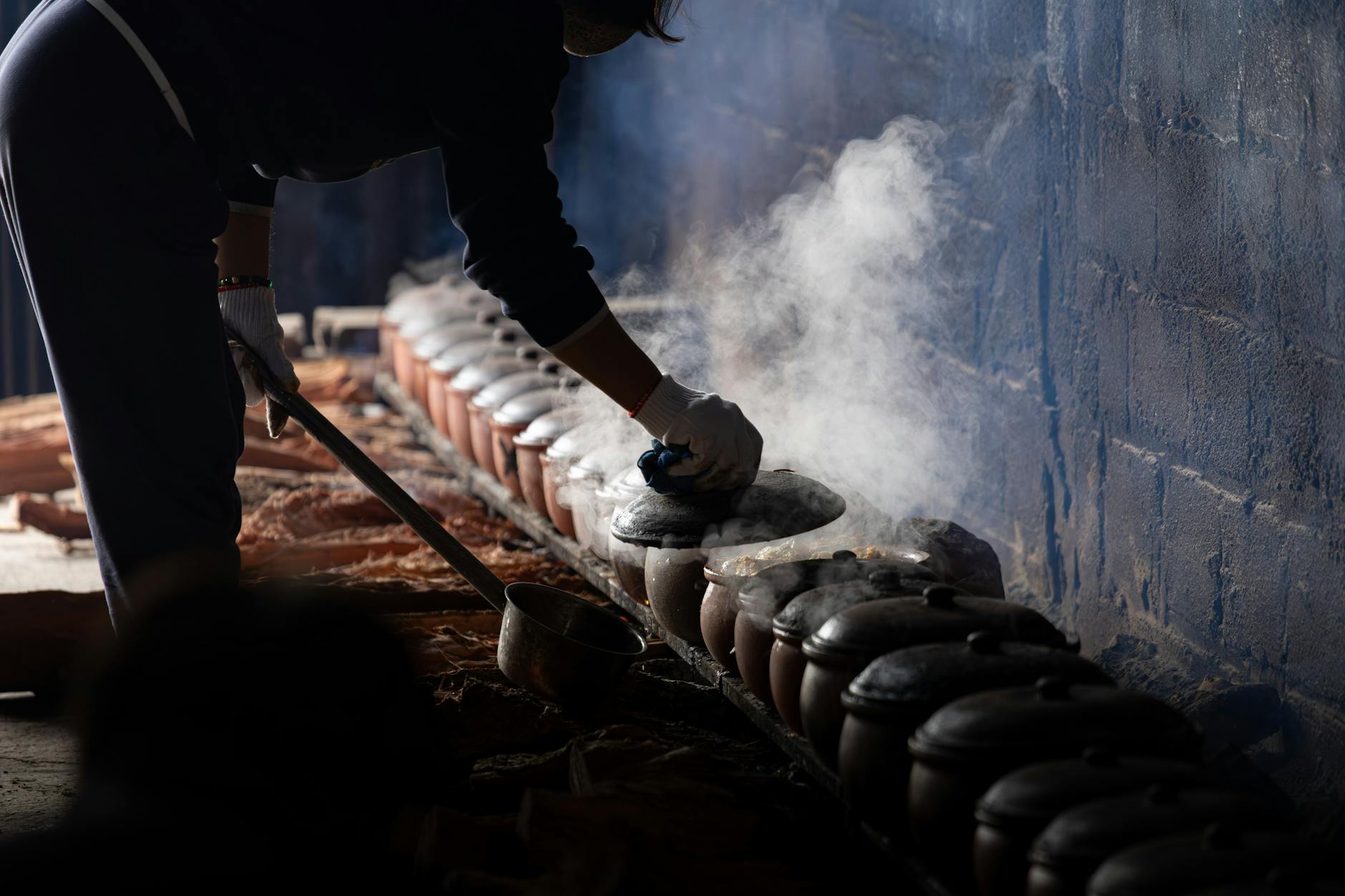 Gotowanie parującego dania w glinianym garnku w góralskiej kuchni