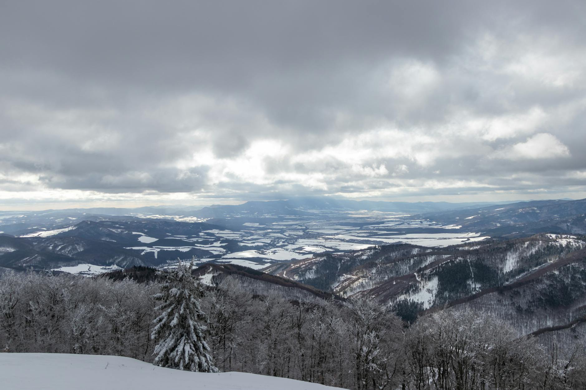Zimowy widok na ośnieżone tatrzańskie szczyty pod pochmurnym niebem