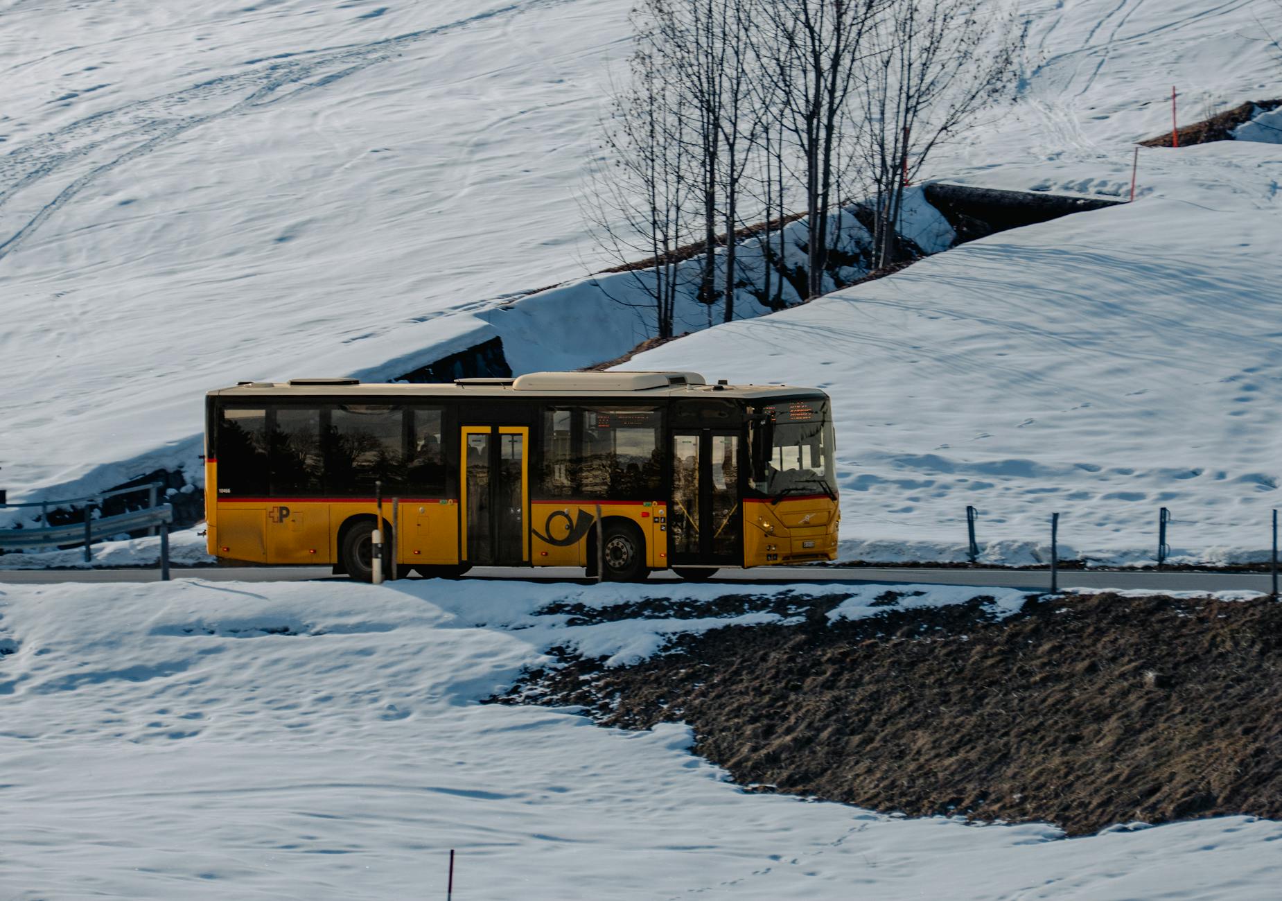 Żółty autobus jedzie zimową, ośnieżoną drogą w górach Podhala