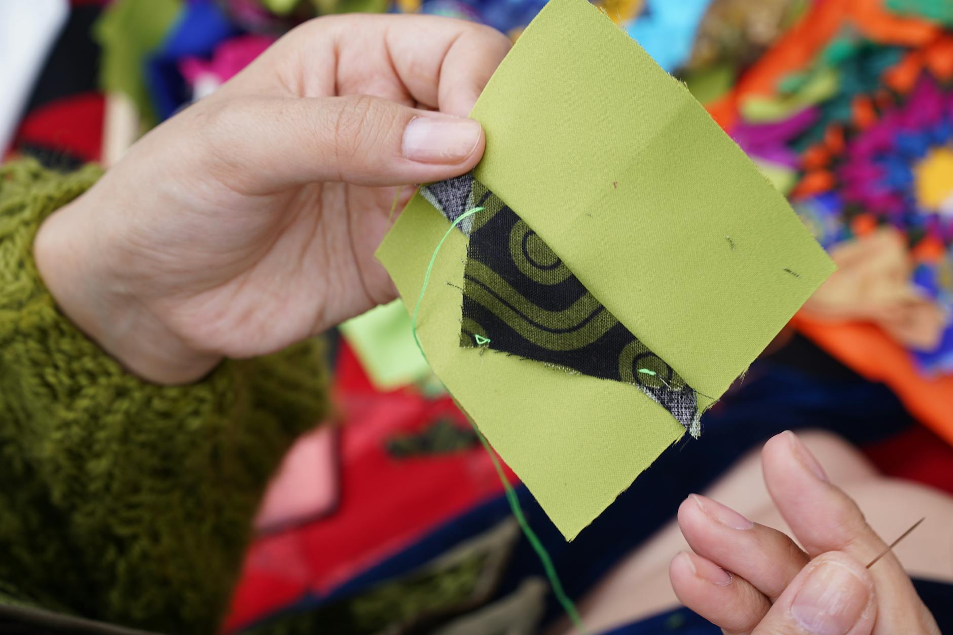 Dłonie szyjące kolorowy patchworkowy koc tradycyjną techniką quiltingu Dłonie szyjące kolorowy patchworkowy koc tradycyjną techniką quiltingu