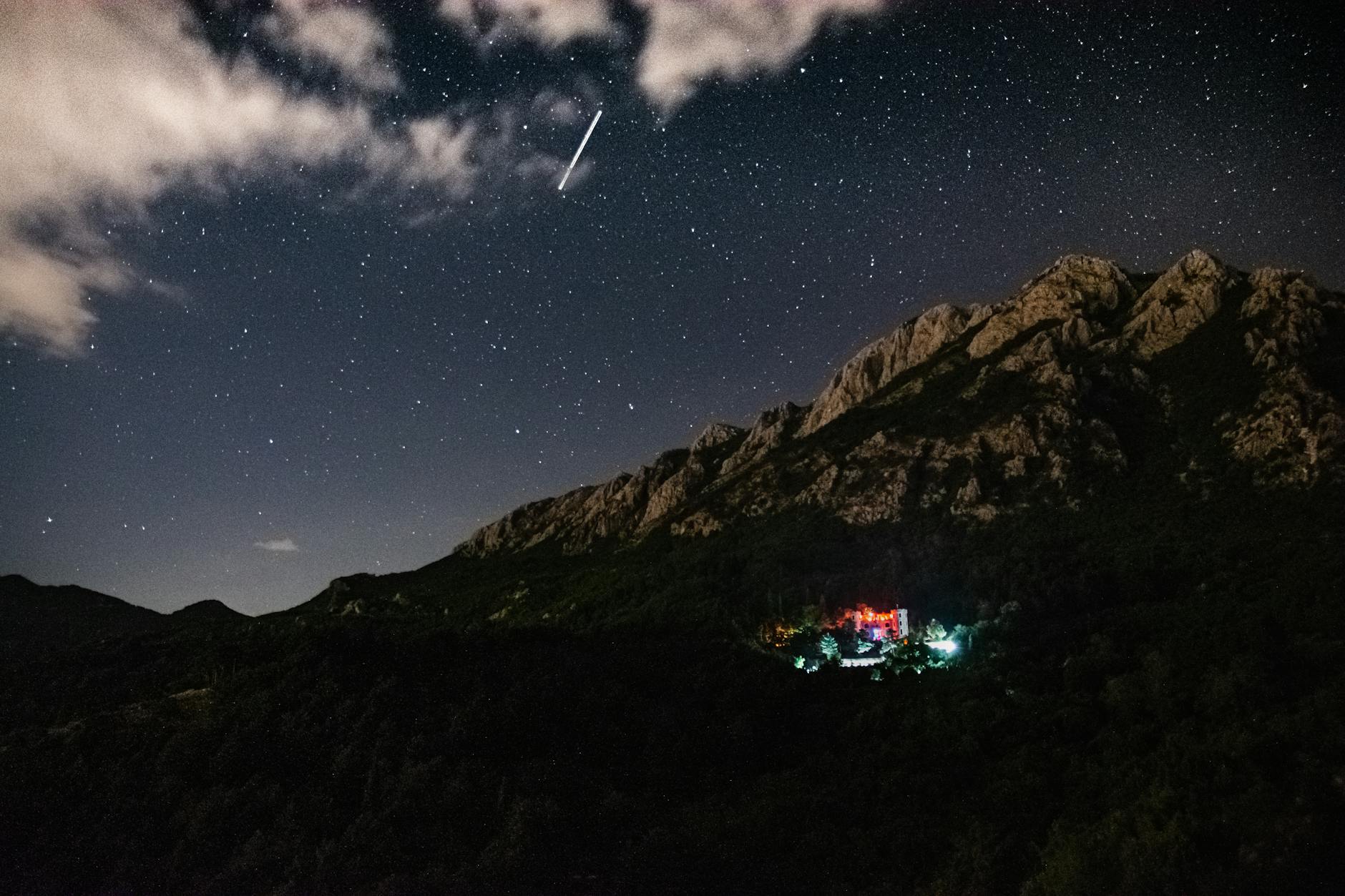 Gwieździste nocne niebo nad górskim krajobrazem przypominającym Tatry