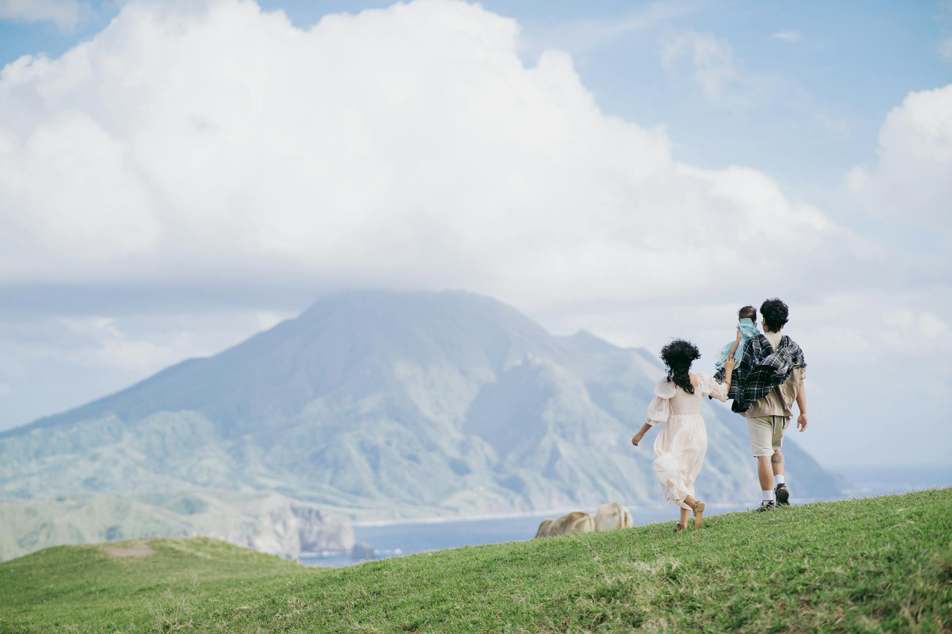 Rodzina z dziećmi spaceruje po zielonym górskim krajobrazie