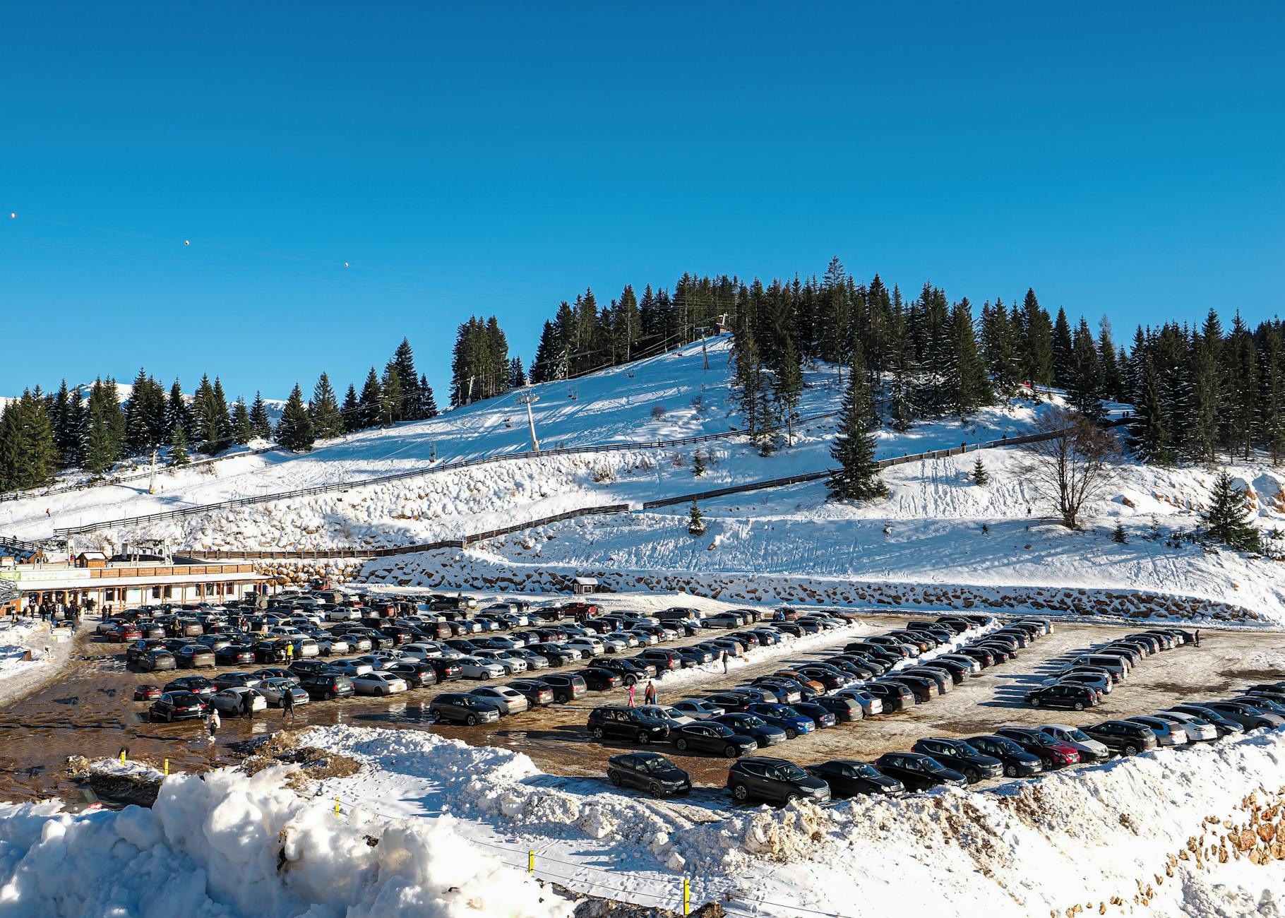 Zaśnieżone Tatry z dużym parkingiem samochodowym na pierwszym planie
