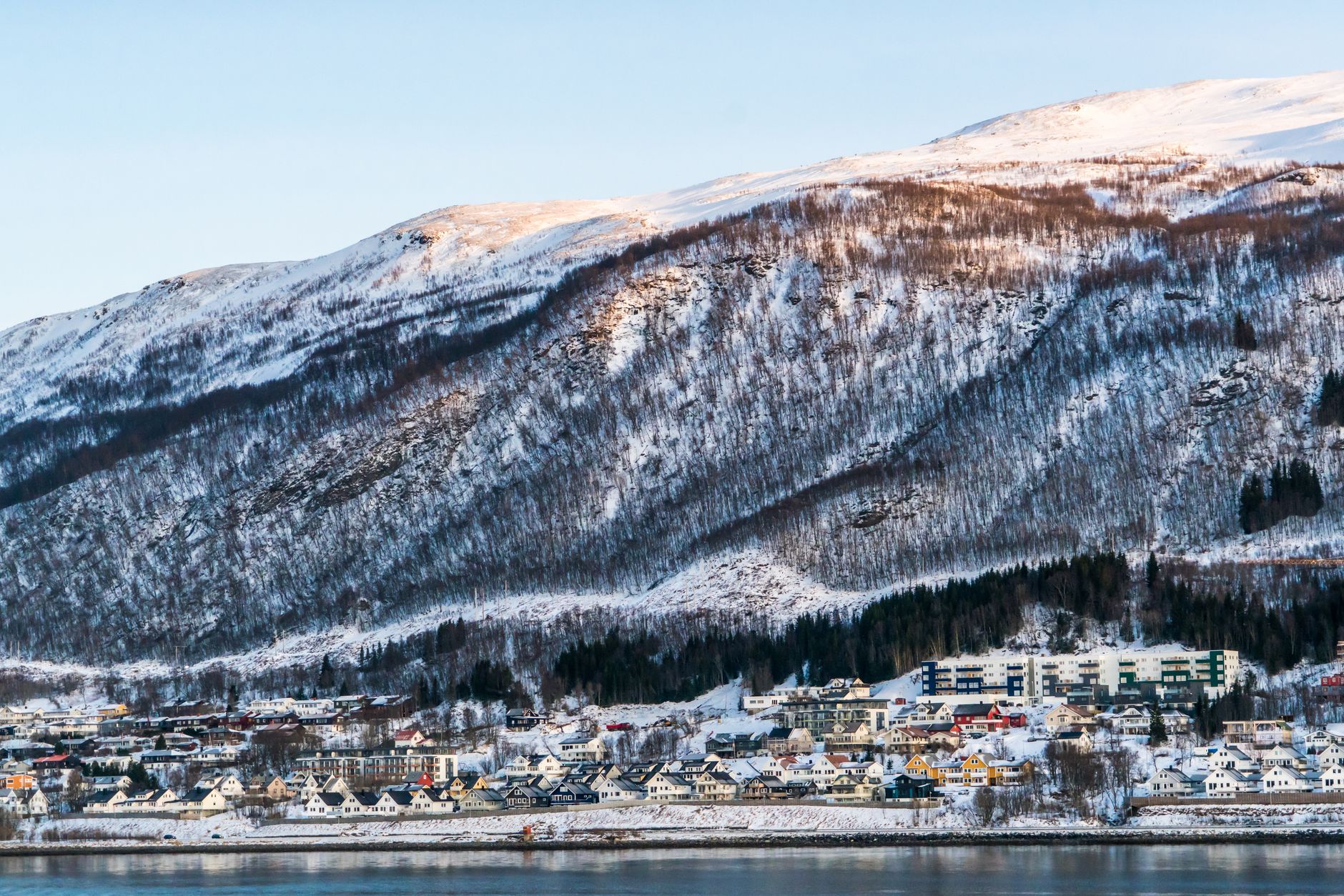 Zimowy widok norweskiego miasteczka u stóp gór nad fiordem